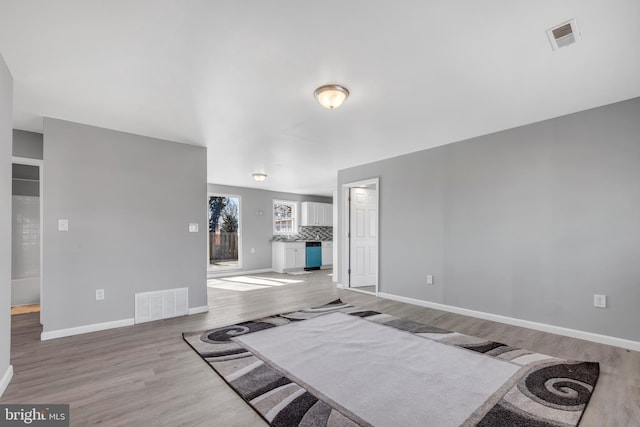 living room featuring baseboards, visible vents, and wood finished floors