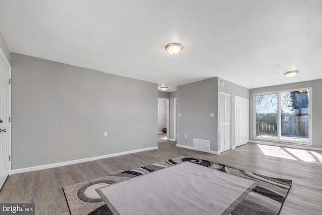 interior space with visible vents, baseboards, and wood finished floors