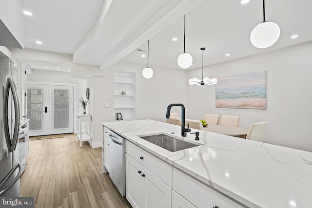 kitchen featuring recessed lighting, stainless steel appliances, a sink, white cabinetry, and light wood-type flooring