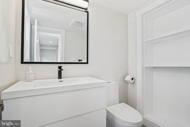 bathroom with visible vents, vanity, and toilet