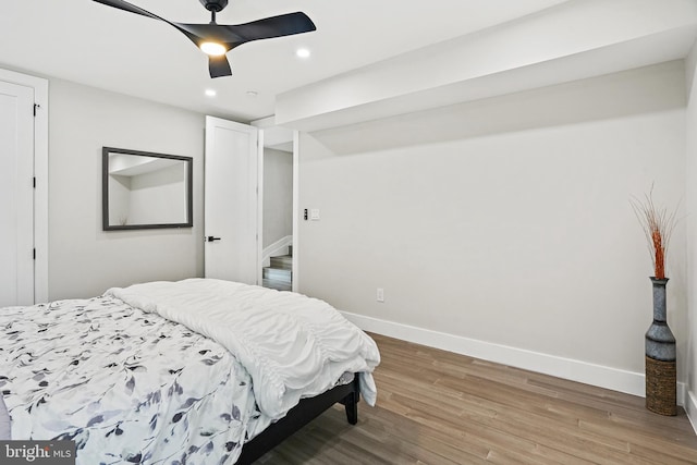 bedroom featuring light wood finished floors, recessed lighting, a ceiling fan, and baseboards