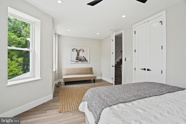 bedroom with recessed lighting, multiple windows, baseboards, and wood finished floors