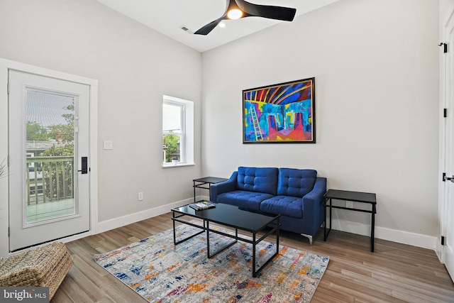 living area with visible vents, baseboards, and wood finished floors