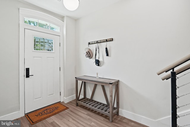 foyer entrance with light wood-style flooring and baseboards