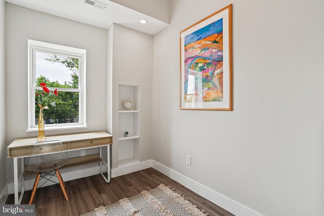 office featuring dark wood-style flooring, visible vents, and baseboards