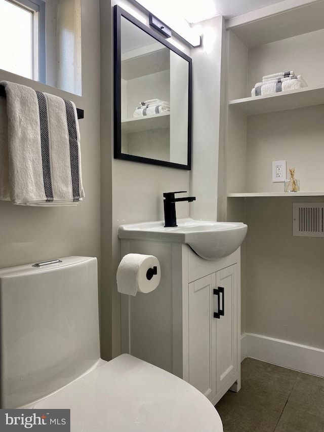 half bath featuring visible vents, tile patterned flooring, vanity, and baseboards