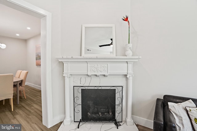 room details with a fireplace, baseboards, wood finished floors, and recessed lighting