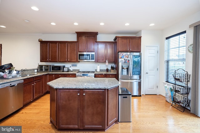 kitchen featuring stainless steel appliances, light wood finished floors, recessed lighting, and a center island