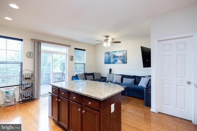 kitchen with light wood-style floors, recessed lighting, a kitchen island, and a ceiling fan