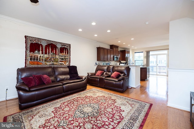 living area featuring light wood-type flooring, crown molding, and recessed lighting