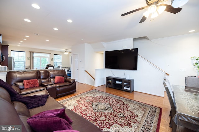 living room featuring baseboards, ornamental molding, wood finished floors, and recessed lighting