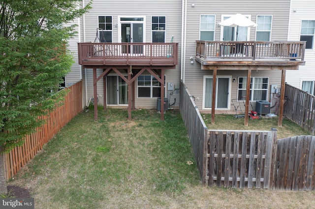 rear view of property featuring a fenced backyard, central AC unit, and a lawn