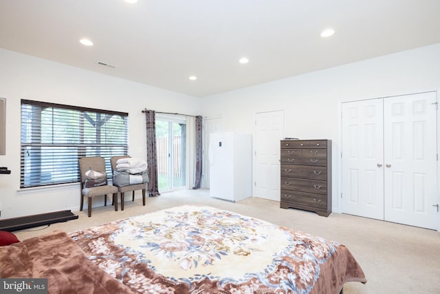 bedroom featuring recessed lighting, visible vents, two closets, and light colored carpet