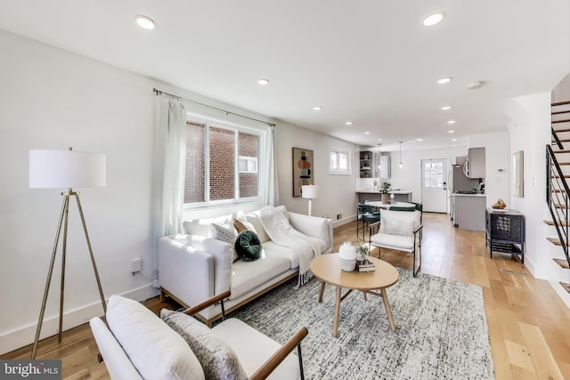 living area featuring stairs, light wood-style flooring, and recessed lighting