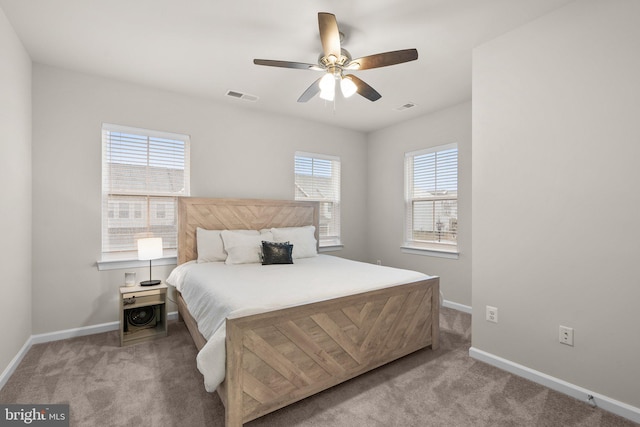 carpeted bedroom with ceiling fan, visible vents, and baseboards