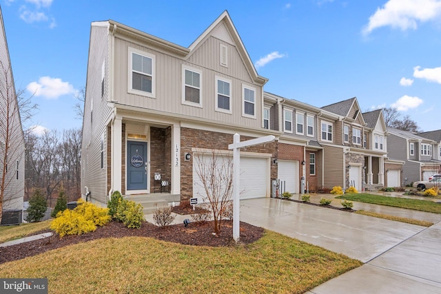 multi unit property with board and batten siding, a garage, a residential view, stone siding, and driveway