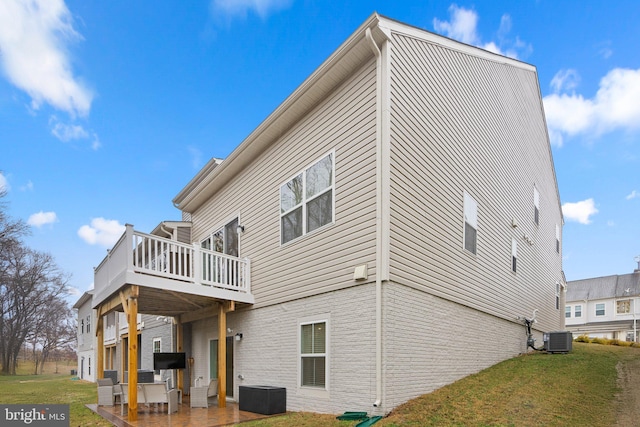 rear view of house with central AC unit, a lawn, and a patio area