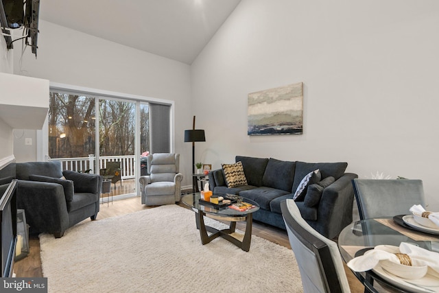 living area with high vaulted ceiling and wood finished floors