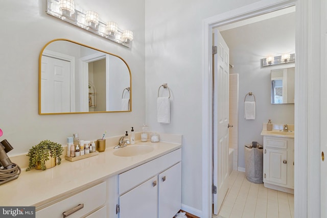 full bath featuring washtub / shower combination, vanity, baseboards, and tile patterned floors