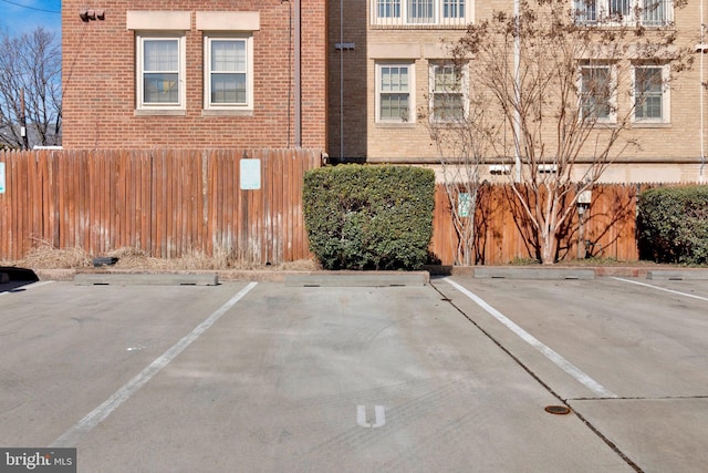 uncovered parking lot featuring fence