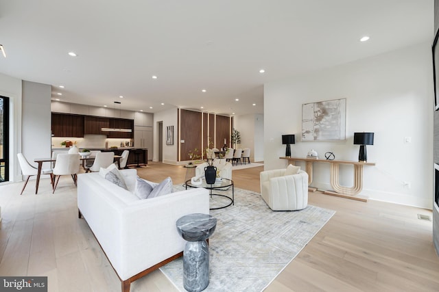 living area featuring recessed lighting, light wood-style flooring, and baseboards