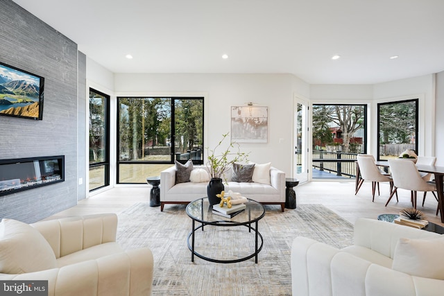 living area featuring a wealth of natural light, a large fireplace, and recessed lighting