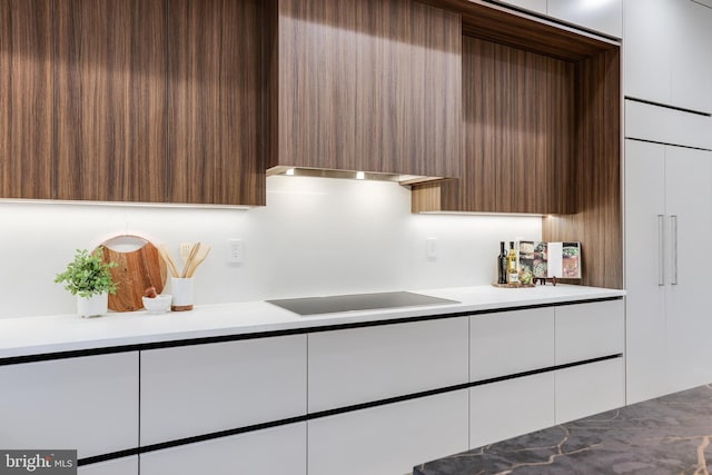 kitchen with light countertops, modern cabinets, and black electric cooktop