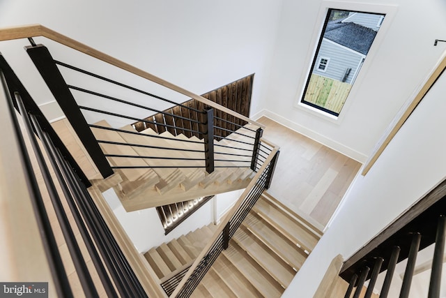 stairway with baseboards and wood finished floors