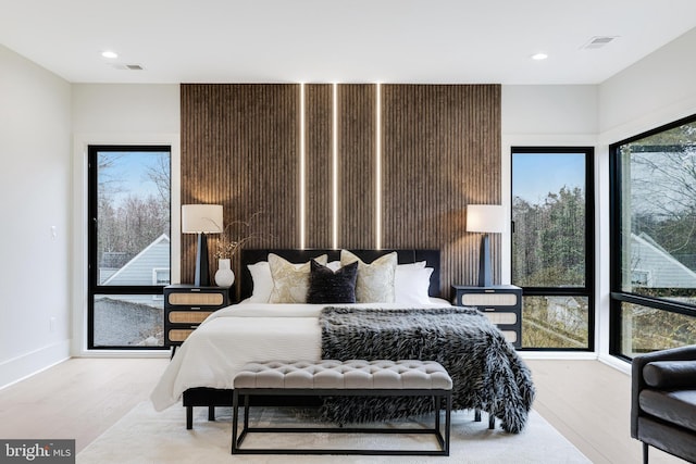 bedroom with baseboards, visible vents, wood finished floors, and recessed lighting