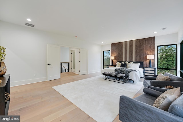 bedroom with recessed lighting, visible vents, light wood finished floors, and multiple windows