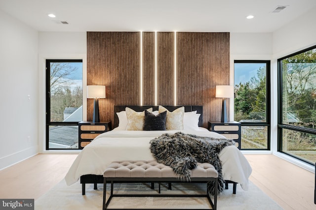 bedroom with recessed lighting, visible vents, baseboards, and wood finished floors