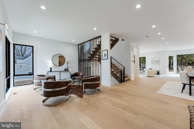 living area with stairs, baseboards, wood finished floors, and recessed lighting