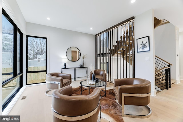 living area featuring stairs, recessed lighting, visible vents, and wood finished floors