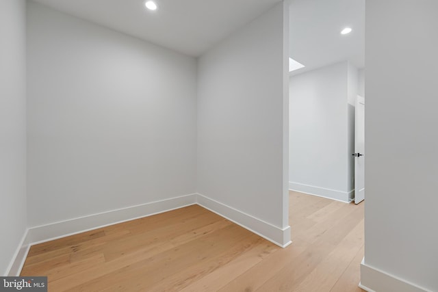 interior space with light wood-style floors, a skylight, baseboards, and recessed lighting