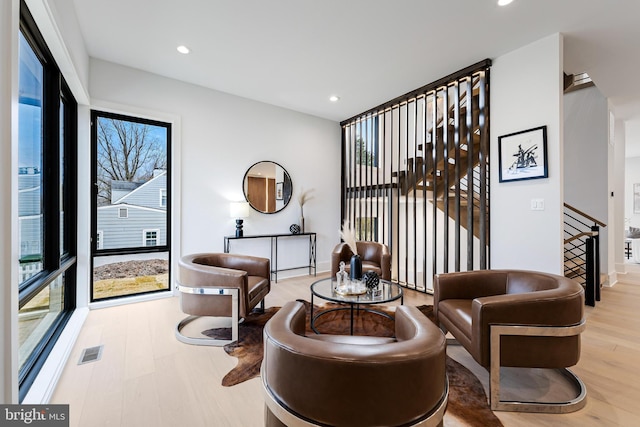 living area with stairs, visible vents, wood finished floors, and recessed lighting