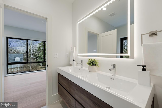 bathroom with double vanity, visible vents, and a sink