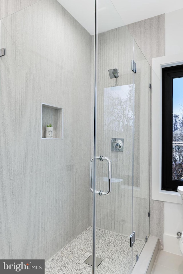 bathroom featuring toilet and a stall shower