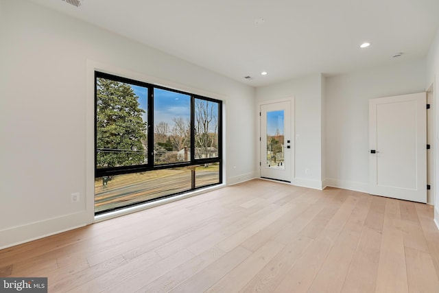 unfurnished room featuring baseboards, light wood-type flooring, and recessed lighting