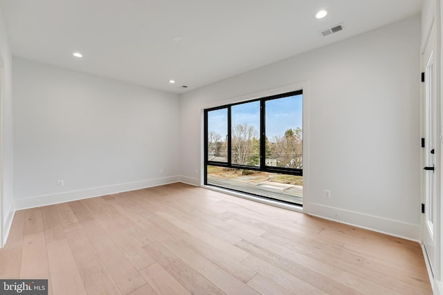 unfurnished room featuring light wood-style floors, baseboards, visible vents, and recessed lighting