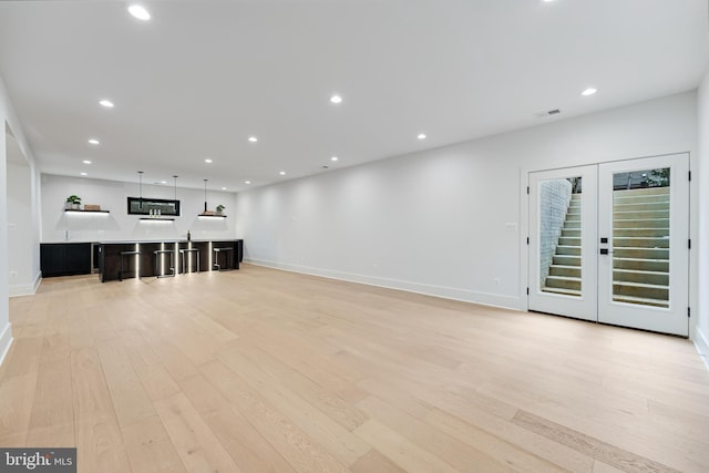 unfurnished living room featuring baseboards, light wood-type flooring, and recessed lighting