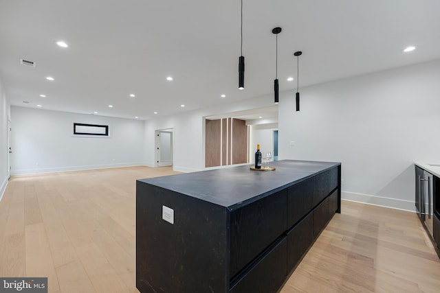 kitchen featuring recessed lighting, visible vents, light wood-style floors, dark cabinetry, and modern cabinets