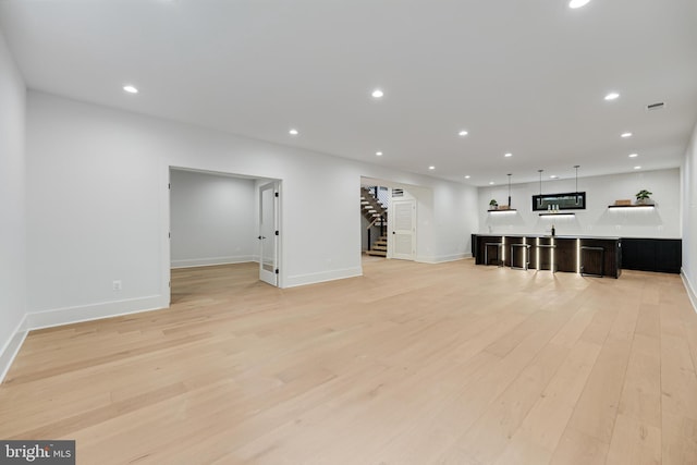 interior space with light wood-style flooring, stairs, baseboards, and recessed lighting