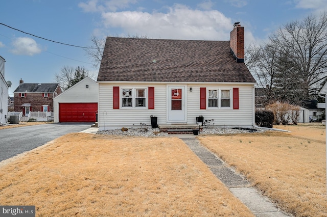 cape cod-style house with central AC, a shingled roof, a chimney, and a front yard