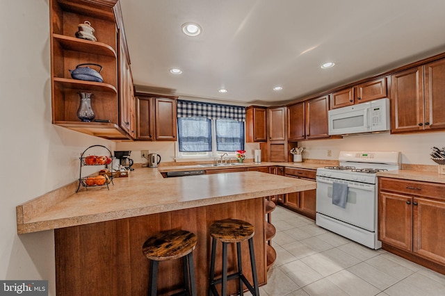 kitchen with white appliances, a peninsula, light countertops, a kitchen bar, and open shelves