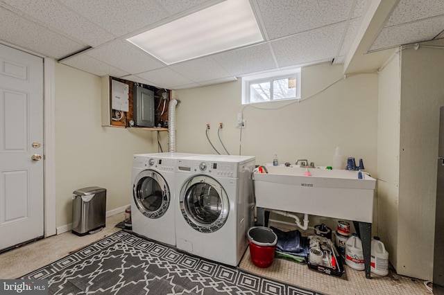 laundry area with laundry area, electric panel, baseboards, and washing machine and clothes dryer