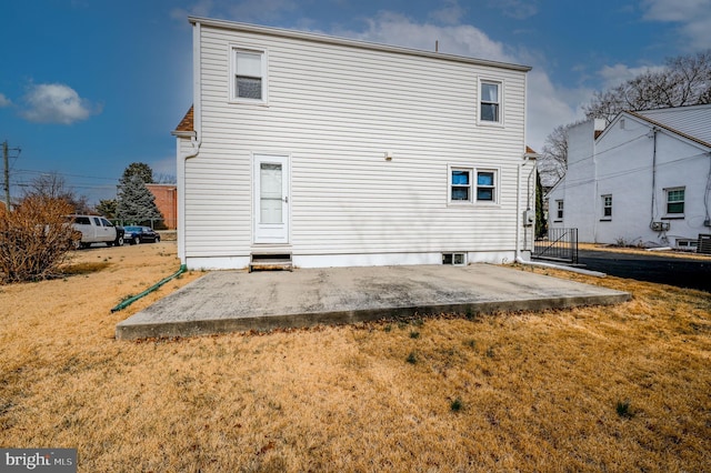 rear view of property featuring a patio and a lawn