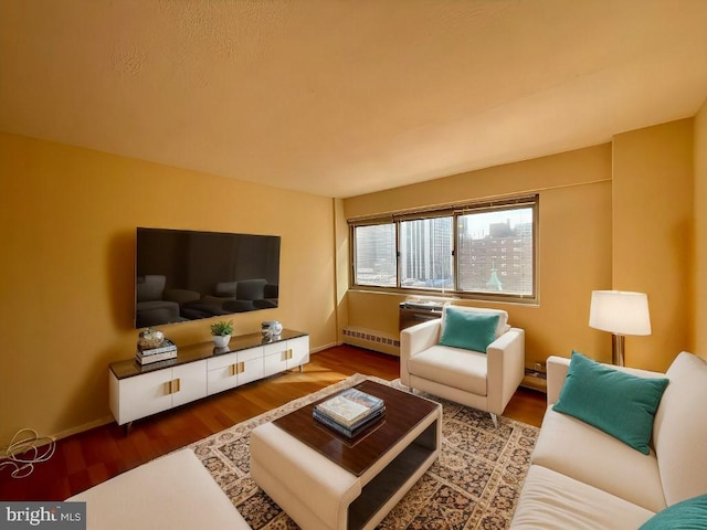 living room featuring baseboards, a baseboard heating unit, and wood finished floors