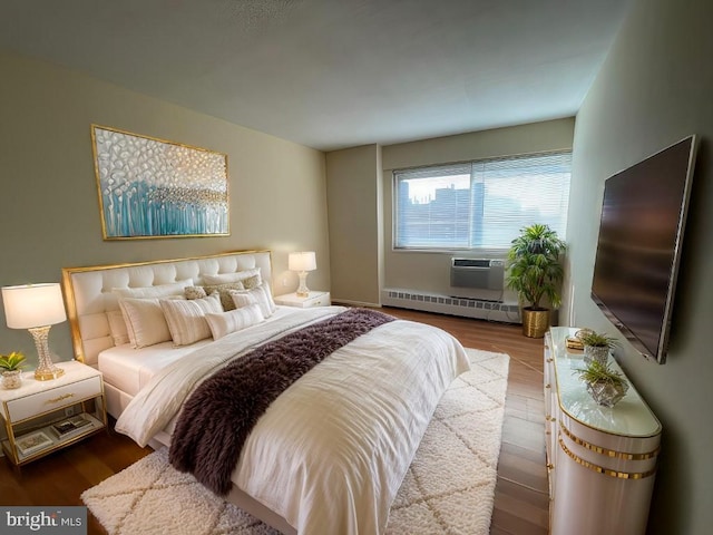 bedroom featuring baseboard heating and wood finished floors