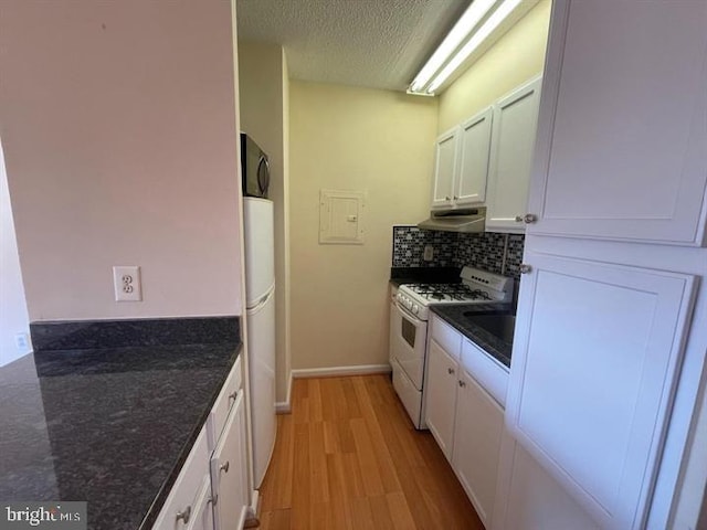 kitchen with white appliances, light wood-type flooring, white cabinetry, and under cabinet range hood