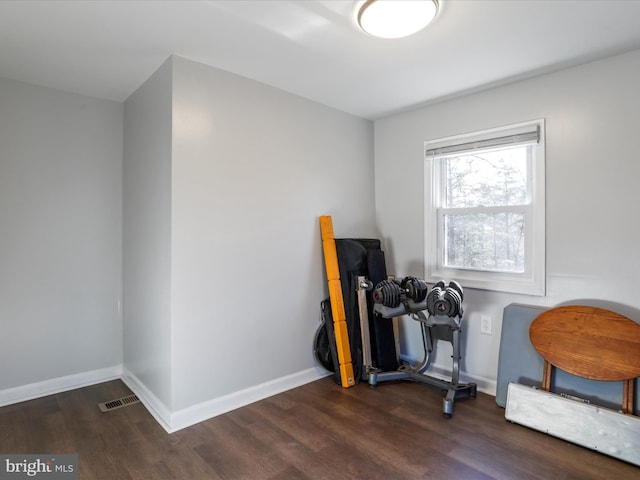 misc room featuring wood finished floors, visible vents, and baseboards